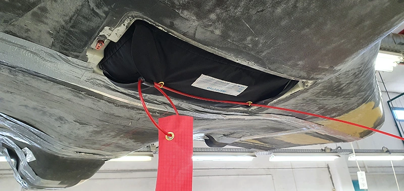 Vano dell'airbag sul ventre della fusoliera di un UAV con una bandierina rossa di sicurezza
